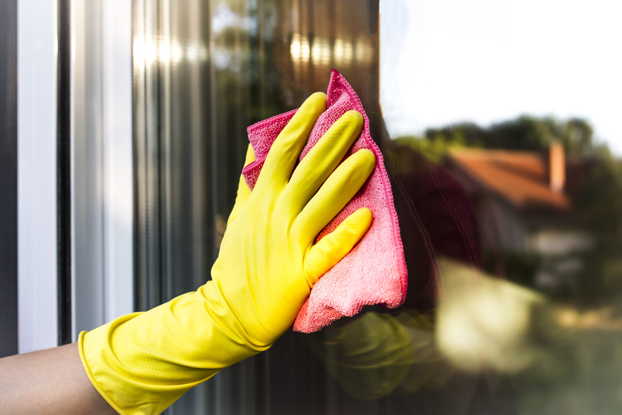 professional cleaning service wiping down a window