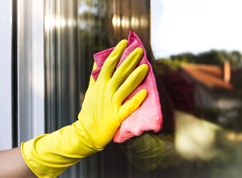 professional cleaning service wiping down a window